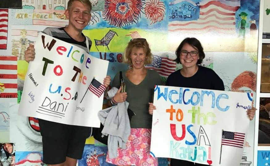 Host mother welcoming two exchange students