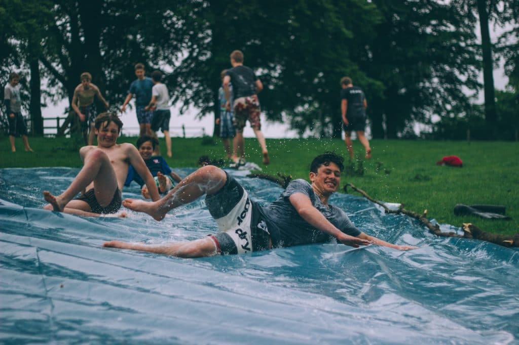 exchange students on water slide with host families