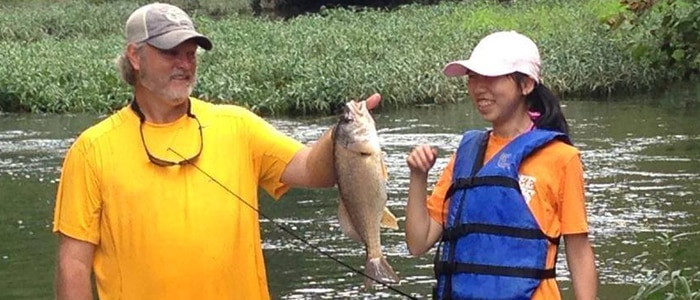 Exchange student studying abroad and fishing with host dad