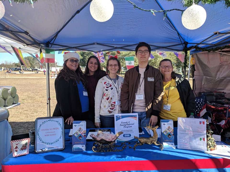 area representative with exchange students at booth